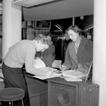 839067 Afbeelding van een informatrice in het inlichtingenbureau in het N.S.-station Utrecht C.S. te Utrecht.